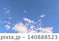 Flock of Birds Flying Across Blue Sky with Clouds Outdoors 140888523