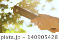 Christian holding a Bible against a background of bright sunlight shining through leaves, Christian faith concept 140905428