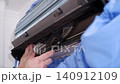Close-up of a service technician cleaning the fan of a split air conditioning system 140912109