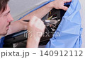 Professional repairman performing maintenance service on an indoor hvac split system unit 140912112