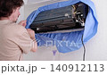 Professional handyman preparing a split system air conditioner for maintenance and deep cleaning 140912113