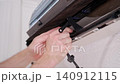 Maintenance technician cleaning the dirty fan and radiator of a home air conditioner with a brush 140912115