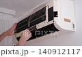 Professional technician performing maintenance service and removing a dirty filter from an ac unit 140912117