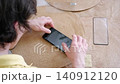 Male hands carefully applying a tempered glass screen protector on a modern mobile phone display 140912120