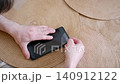 Male hands carefully applying a new protective glass film on a smartphone screen at home 140912122