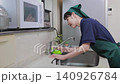 House cleaning staff cleaning the kitchen faucet 140926784