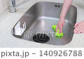 The hands of a house cleaning staff member as they clean the sink with a sponge. 140926788