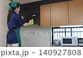 Female house cleaning staff cleaning a range hood 140927808