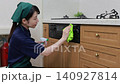 A house cleaning staff member wipes down the front of the kitchen grill. 140927814