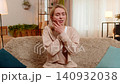 Adult woman sitting on sofa holding cheek with hand showing strong tooth pain, discomfort at home 140932038