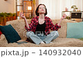 Young woman writing reflections in journal at home after meditation, calm and satisfied chill relax 140932040