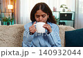 Indian woman drinking tea with peaceful face at home enjoying calm personal moment of relaxation 140932044