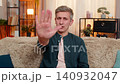 Young man shows stop gesture with raised hand strict face expressing emotional boundary or rejection 140932047