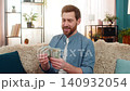 Man holding stack of dollar cash banknotes counting money smiling feeling happy about big earnings 140932054