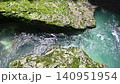 Top view of a stream of clear turquoise water flowing through a narrow rocky gorge 140951954