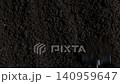 Garden rake smoothing dark fertile soil surface in overhead close-up 140959647