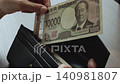 一万円札と長財布　お財布からお金を出す女性の手元 140981807
