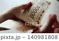 一万円札を数える女性の手元 140981808
