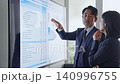 一群商務人士一邊看著螢幕一邊交談。 （會議、商務談判、簡報、諮詢、管理） 140996755
