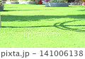 Young boy playing with colorful steering wheel equipment at a sunny outdoor public park playground 141006138