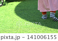 Child walking on a lush green lawn in a sunny park during a bright summer afternoon outdoor session 141006155