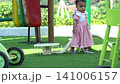 Child walking on a lush green lawn in a sunny park during a bright summer afternoon outdoor session 141006157