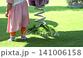 Child walking on a lush green lawn in a sunny park during a bright summer afternoon outdoor session 141006158