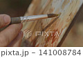 Close-up, the artist's hand paints an autumn forest landscape with watercolor on a sunny day 141008784