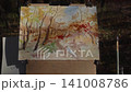 An autumn landscape painted in watercolor stands on an easel in the forest 141008786