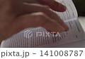 Close-up, a woman's hand turning a page of a book while reading 141008787