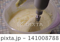 Adding the cream mass to the bowl where the cake cream is beaten with a mixer 141008788
