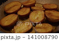 Potatoes cut in half, fried in oil in a pan 141008790