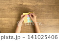 A child's hand peeling a yellow circular sticker from its backing - 4K silent slow-motion video 141025406