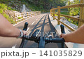 POV of cyclist riding on asphalt bike path at sunset in summer 141035829