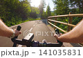 POV of cyclist riding on asphalt bike path at sunset in summer 141035831