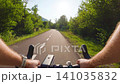 POV of cyclist riding on asphalt bike path at sunset in summer 141035832