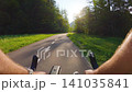 POV of cyclist riding on asphalt bike path at sunset in summer 141035841
