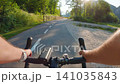 POV of cyclist riding on asphalt bike path at sunset in summer 141035843