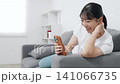 A teenage woman using a smartphone in the living room 141066735