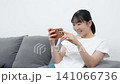 A teenage woman using a smartphone in the living room 141066736