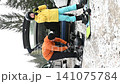 Snowboarders preparing their gear by the car before hitting the slopes. 141075784