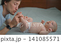 Father kissing little feet of his three month old baby son on bed. 141085571