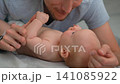 Father listening to baby cooing and kissing his infant son. Close-up. 141085922