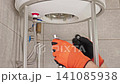 Plumber Removing Water Heater Cover During Maintenance Service, Preparing Appliance For Cleaning, Inspection And Limescale Removal 141085938