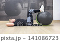 A person performs core exercises with an exercise ball in a gym. The workout focuses on stability and abdominal strength 141086723