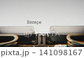 Old mechanical typewriter typing Escape Boundaries in a close up view, with metal letters striking the white paper. 141098167