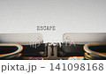 Old mechanical typewriter typing Escape in a close up view, with metal letters striking the white paper. 141098168