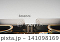 Old mechanical typewriter typing Essence Of Being in a close up view, with metal letters striking the white paper. 141098169