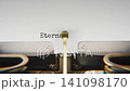 Old mechanical typewriter typing Eternal Life in a close up view, with metal letters striking the white paper. 141098170