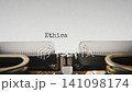 Old mechanical typewriter typing Ethical Dilemma in a close up view, with metal letters striking the white paper. 141098174